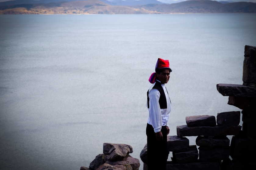 Man in traditional Peruvian costume wearing chullo hat on Taquile Island on Lake Titicaca